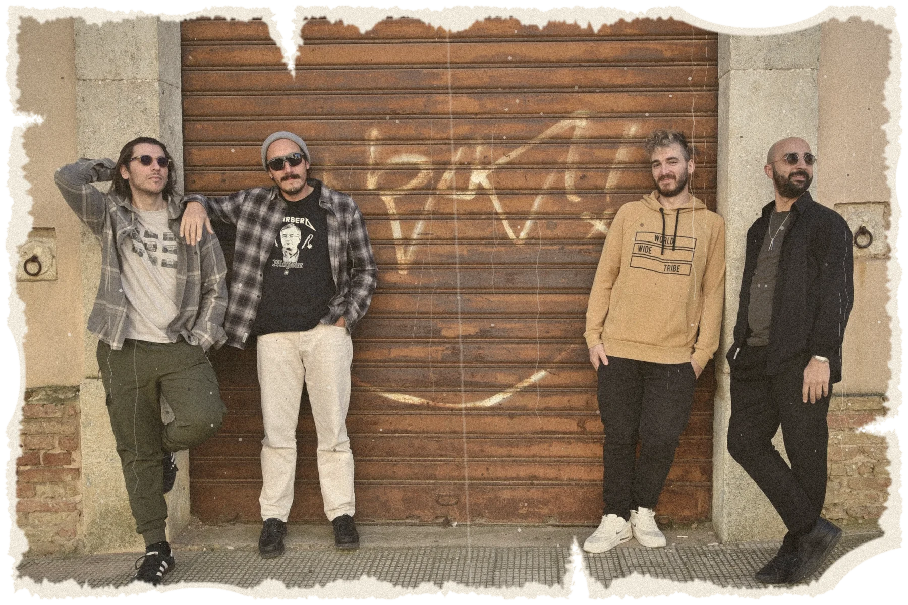 I Cìuz – Domenico, Peppe, Elia e Luca – appoggiati a una vecchia saracinesca, in una foto dai bordi strappati
